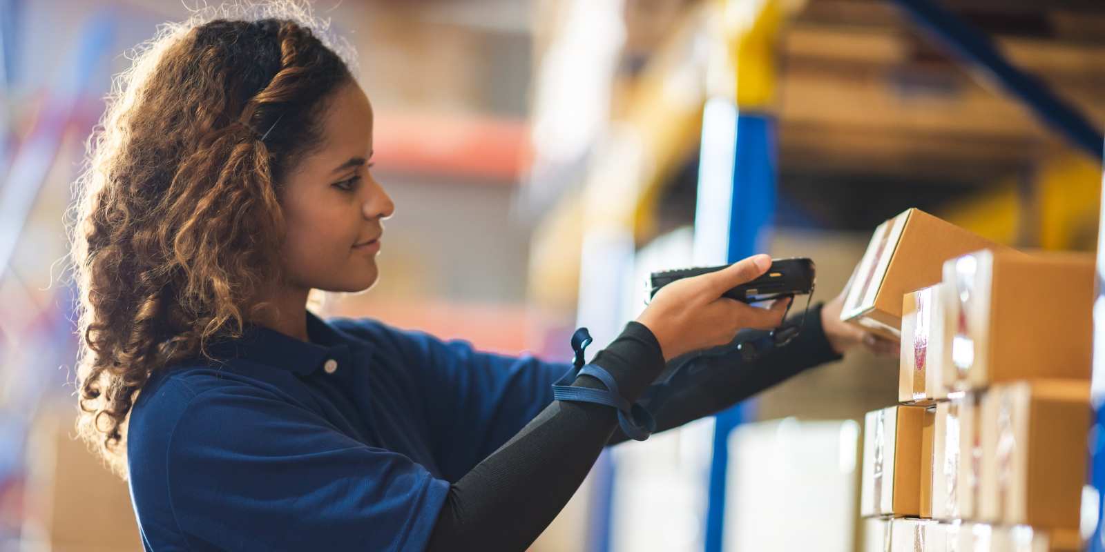 Female Warehouse worker stocking retail items on a shelf