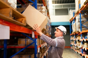 Warehouse Material Handler Organizing Boxes on High Shelves